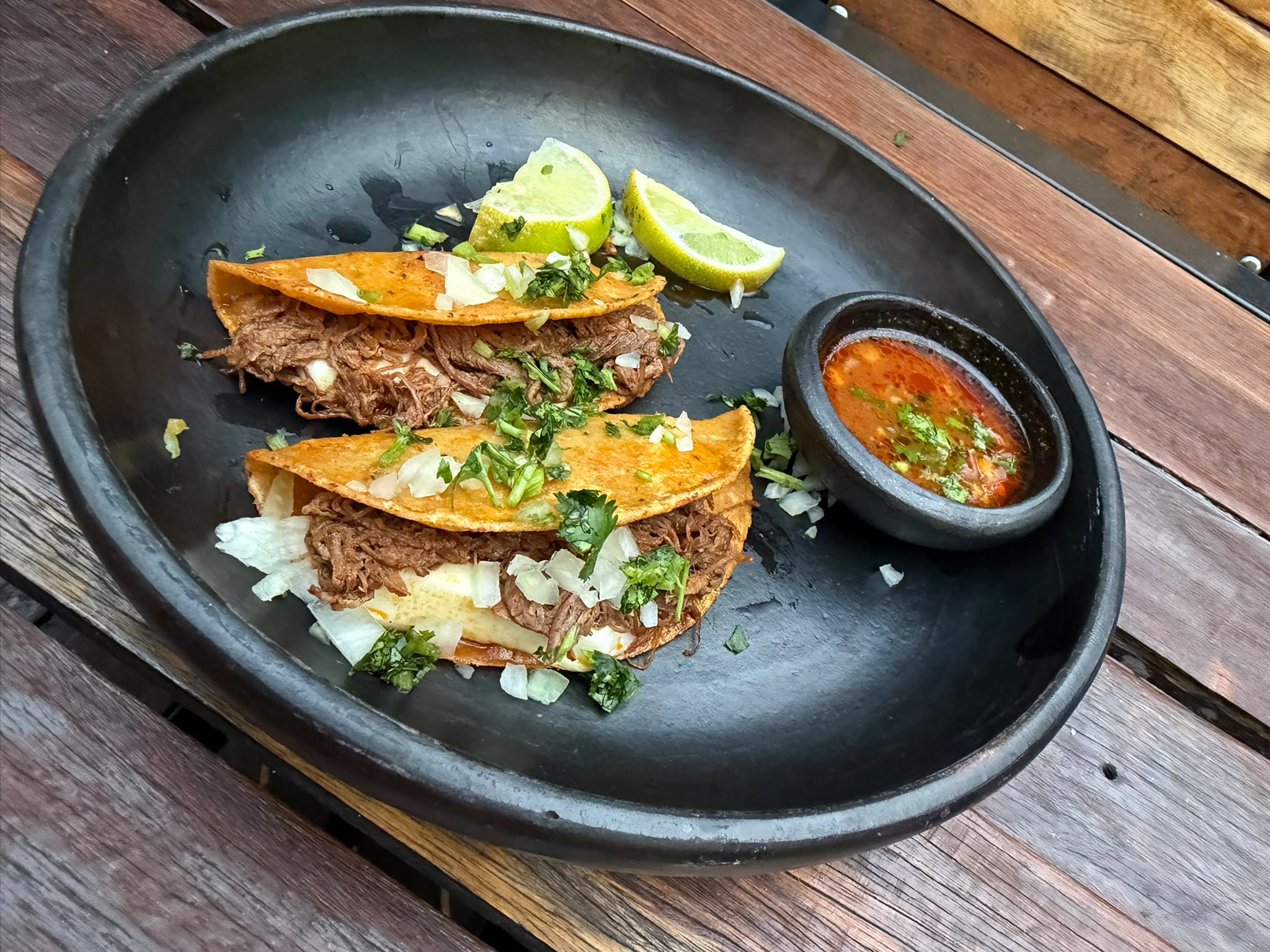 Tacos de birria con consomé y limón